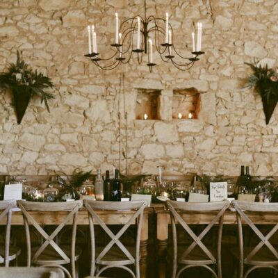 Le Chai salle de reception au domaine de La Leotardie avec une grande table pour les mariés.