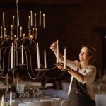 woman lighting candle holders for a wedding in leotardy