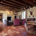 living room with armchairs and sofas and exposed wooden beams in a chateau