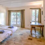 bedroom with 2 single beds, a table and chairs and a door to the outside