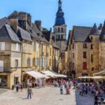 view of a square with people sitting at cafes in Sarlat Dordogne